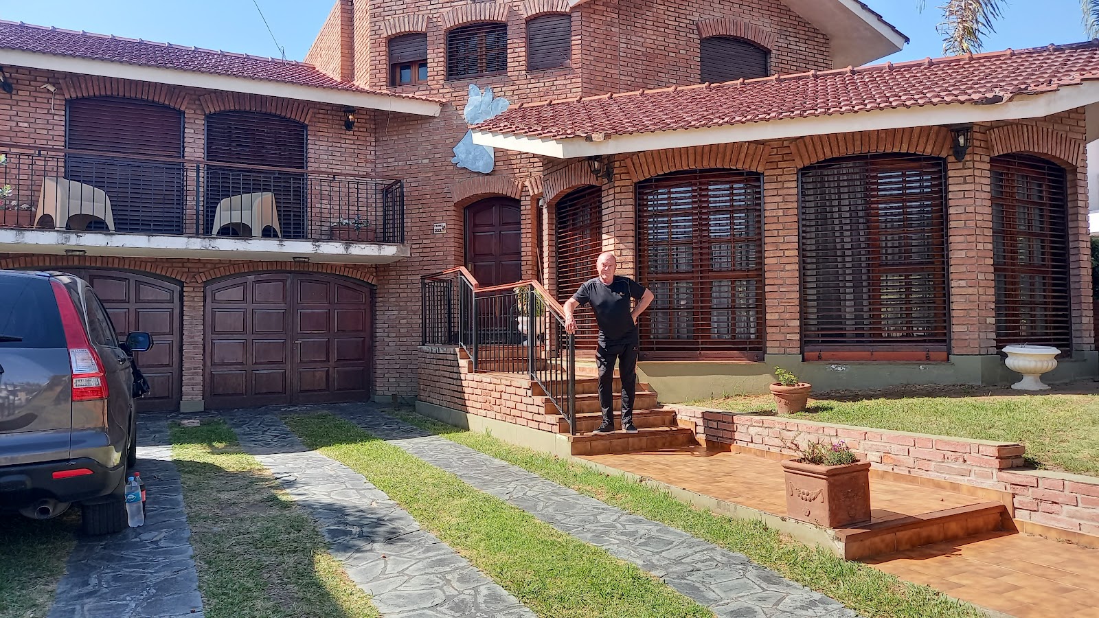 Fachada del Hotel del Carmen con uno de sus dueños en la entrada