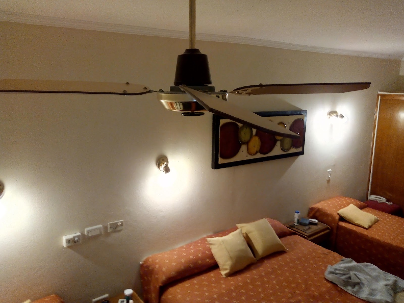Habitación del Hotel del Carmen con camas individuales, ventilador de techo y luz cálida